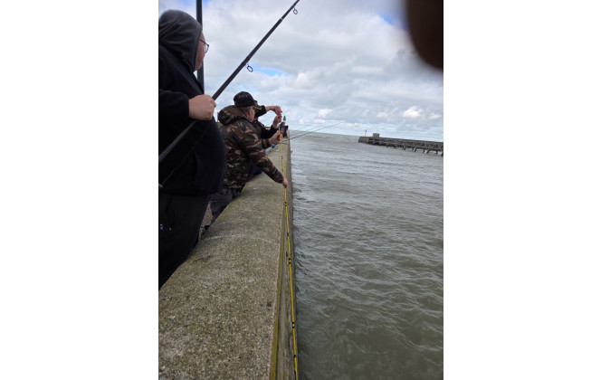 Technique de pêche spéciale de Marco qui consiste à jeter sa canne à l'eau, puis à la faire repêcher par un collègue.
